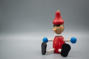 a wooden pinocchio toy in close up photography