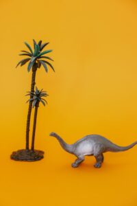 dinosaur and a palm tree toy figurine